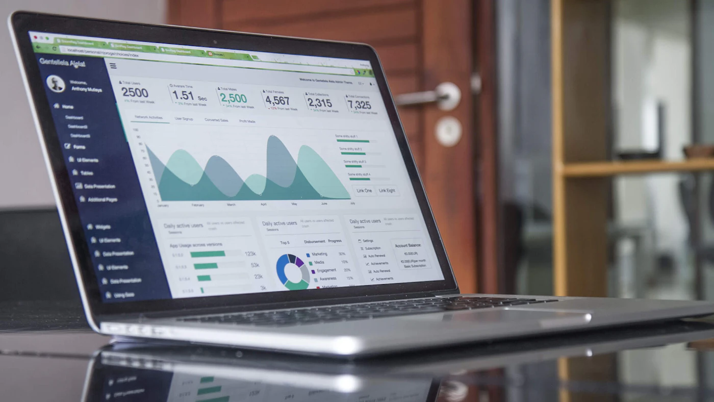 Laptop menampilkan grafik dan data analitik di atas meja kerja