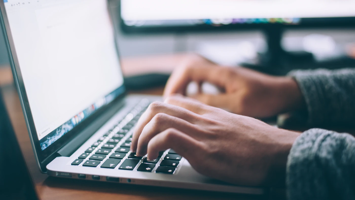 Tangan mengetik di keyboard laptop