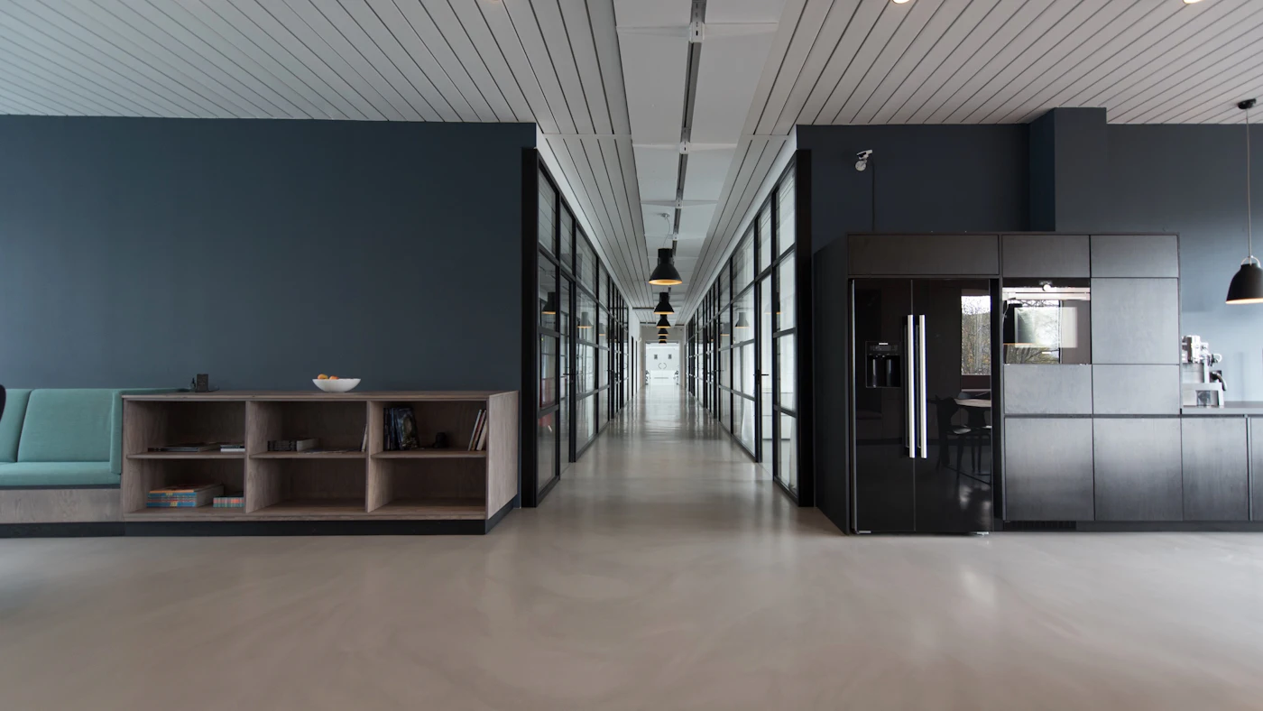 An empty, bright modern office corridor with glass walls