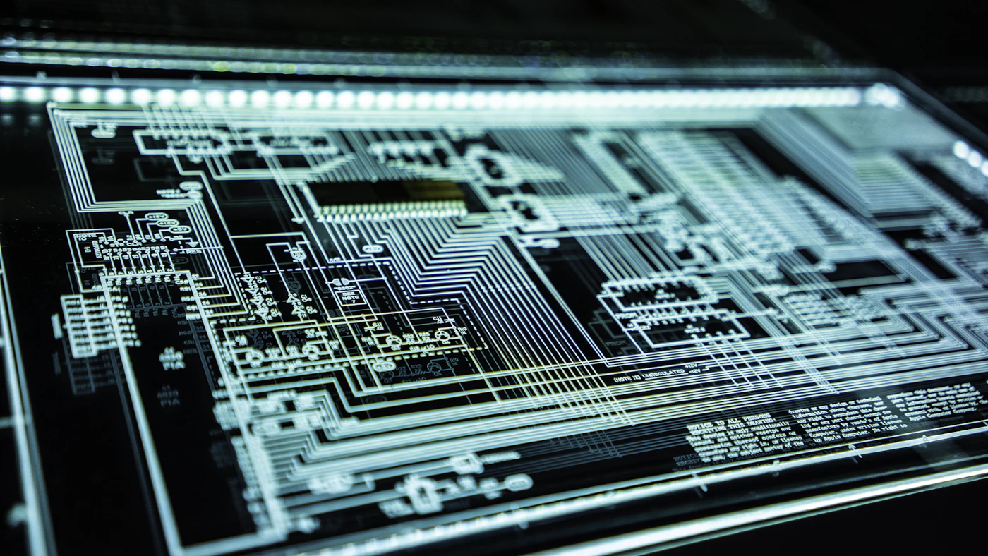 A glowing circuit board with traces of the circuit, seen at an angle