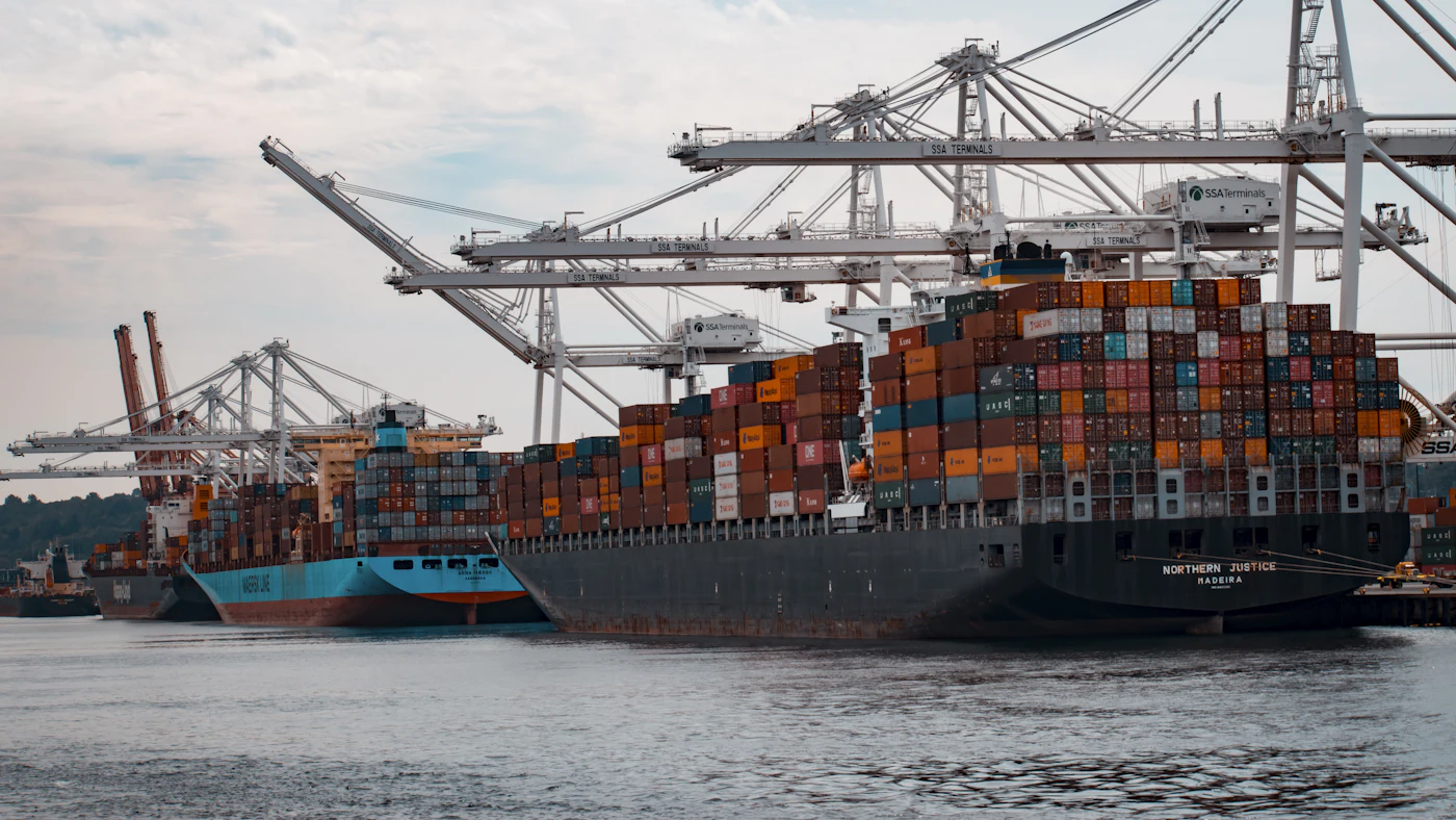 A container port with large cranes and a ship loaded with containers