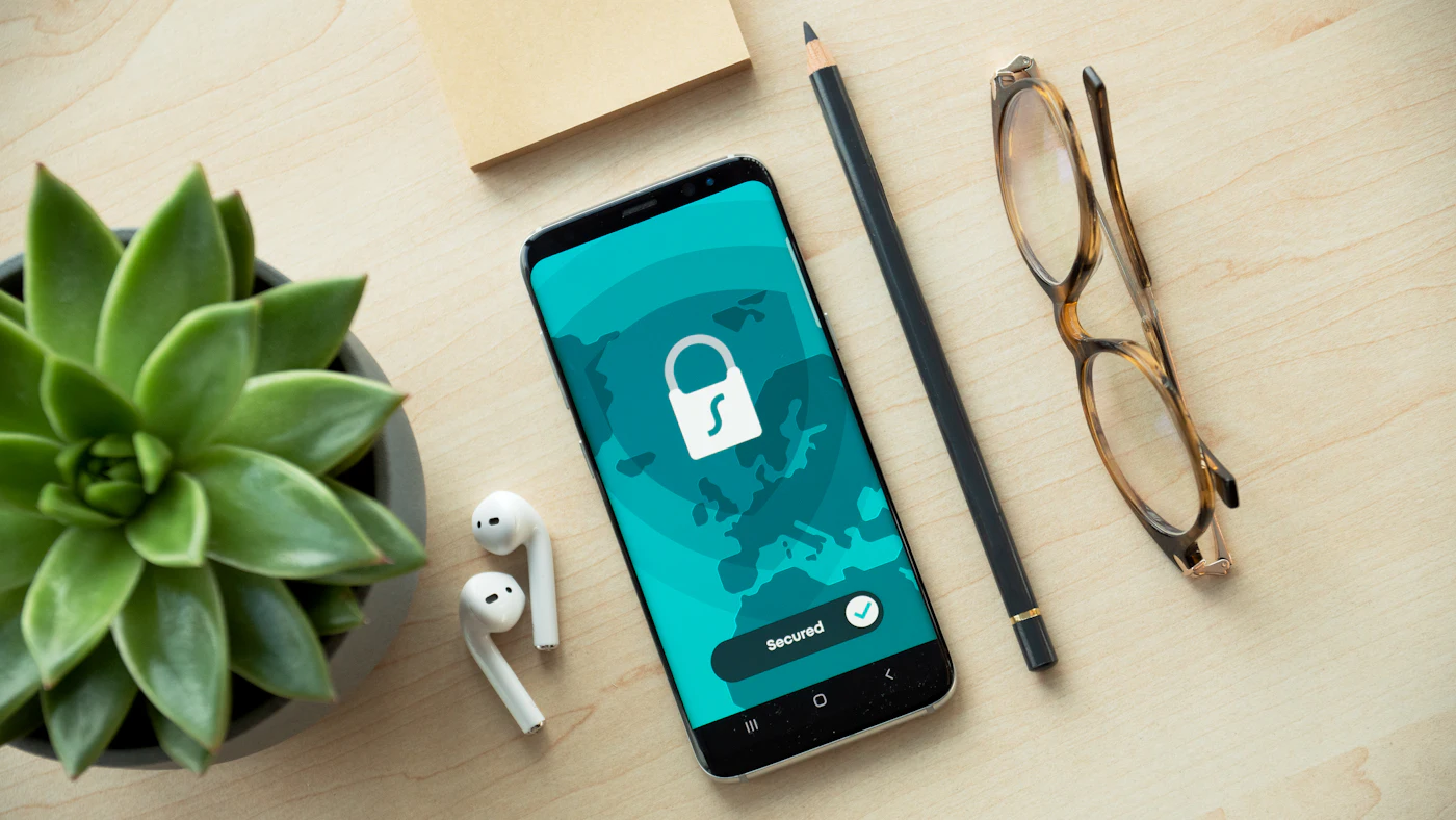 A smartphone showing a security lock icon on a wooden table
