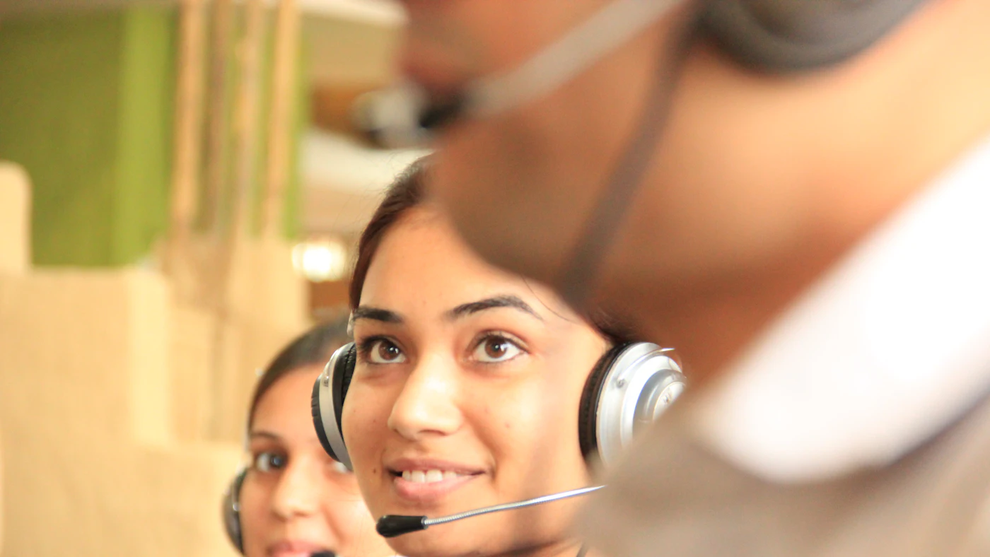 Two women wearing headsets in a bright office workspace